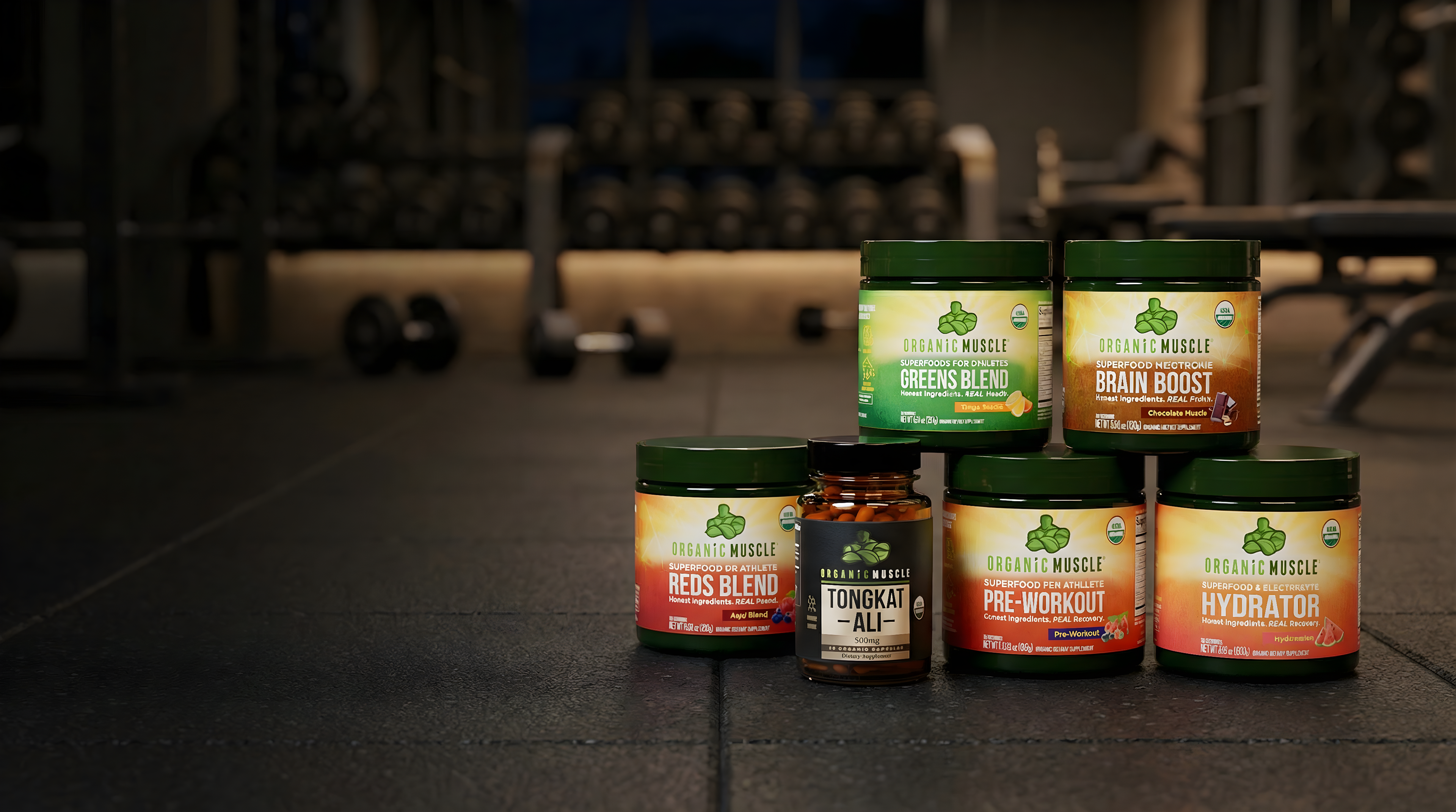 Supplement jars from Natural Muscle in a gym setting